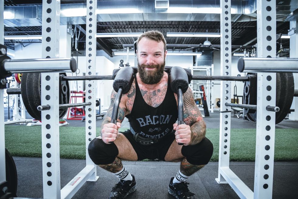 Hairy tattooed smiling man at the gym