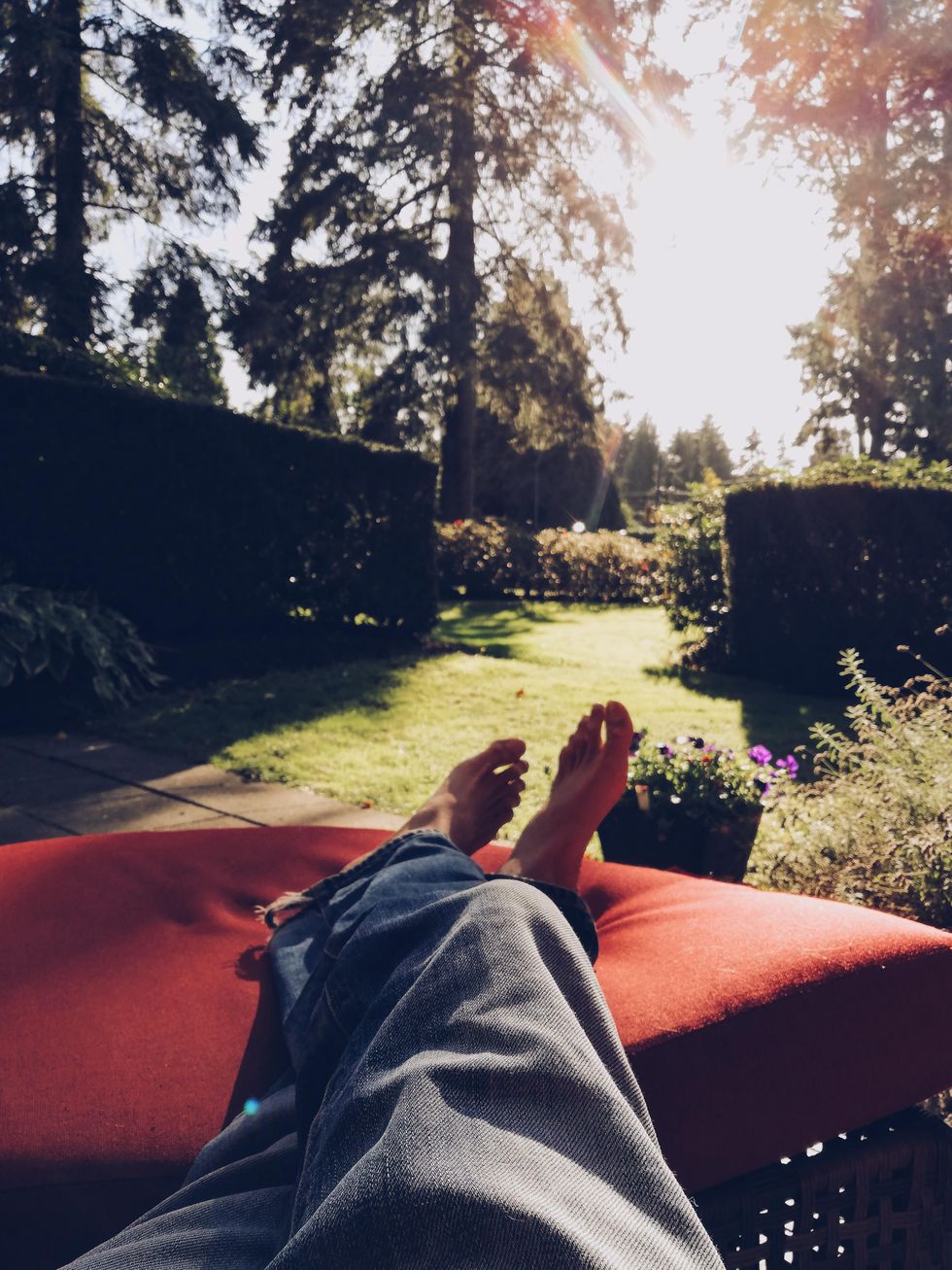 Person laying in their backyard wearing jeans