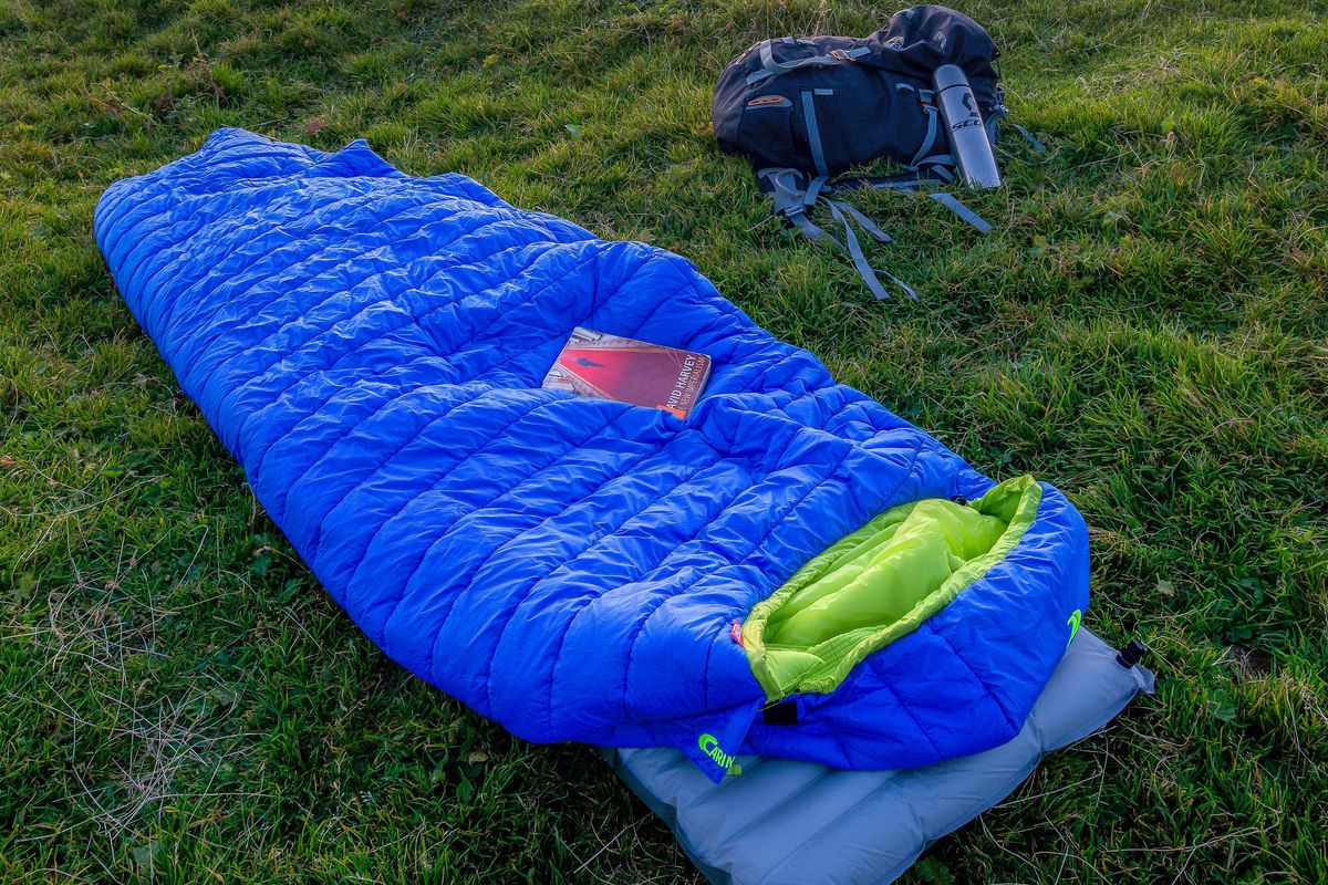 blue sleeping bag on mountain during daytime.