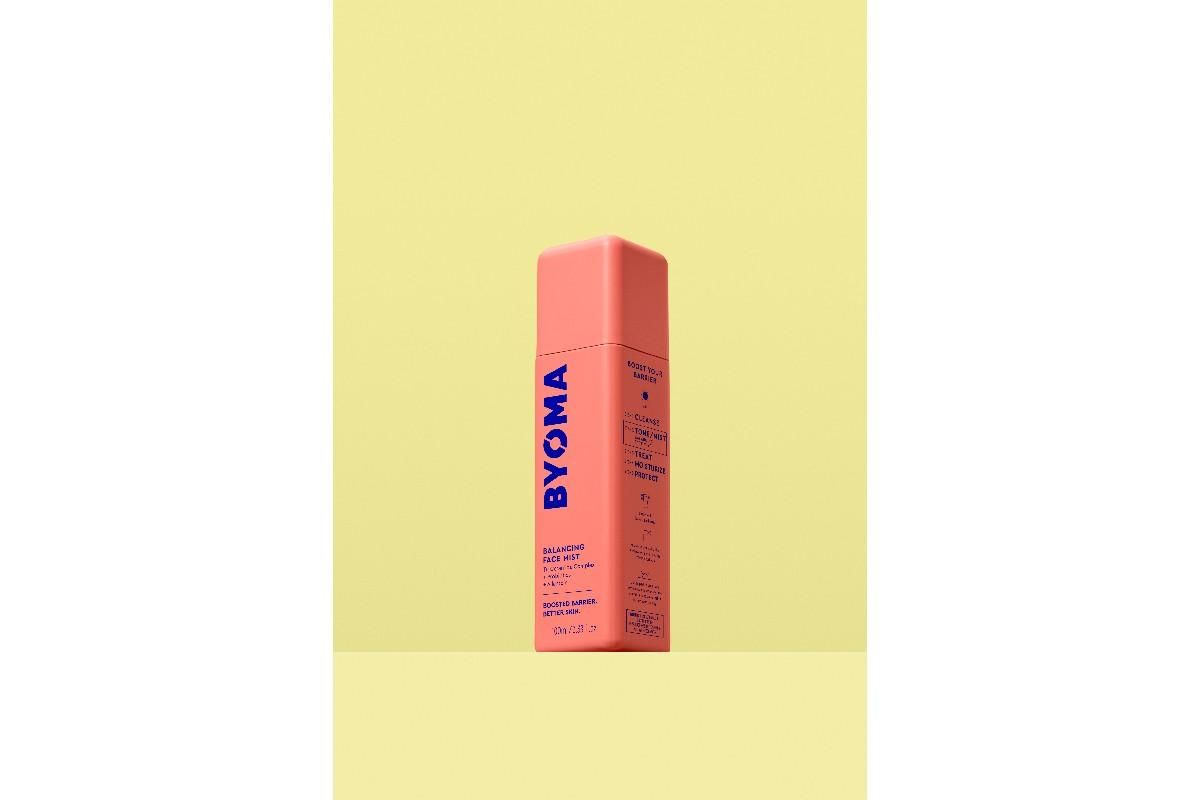 Orange bottle of BYOMA Balancing Face Mist against a yellow background.