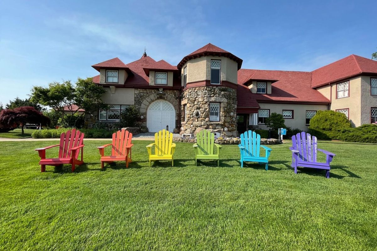 rainbow colored Adirondack chairs lined in front of the Ocean Edge Resort.