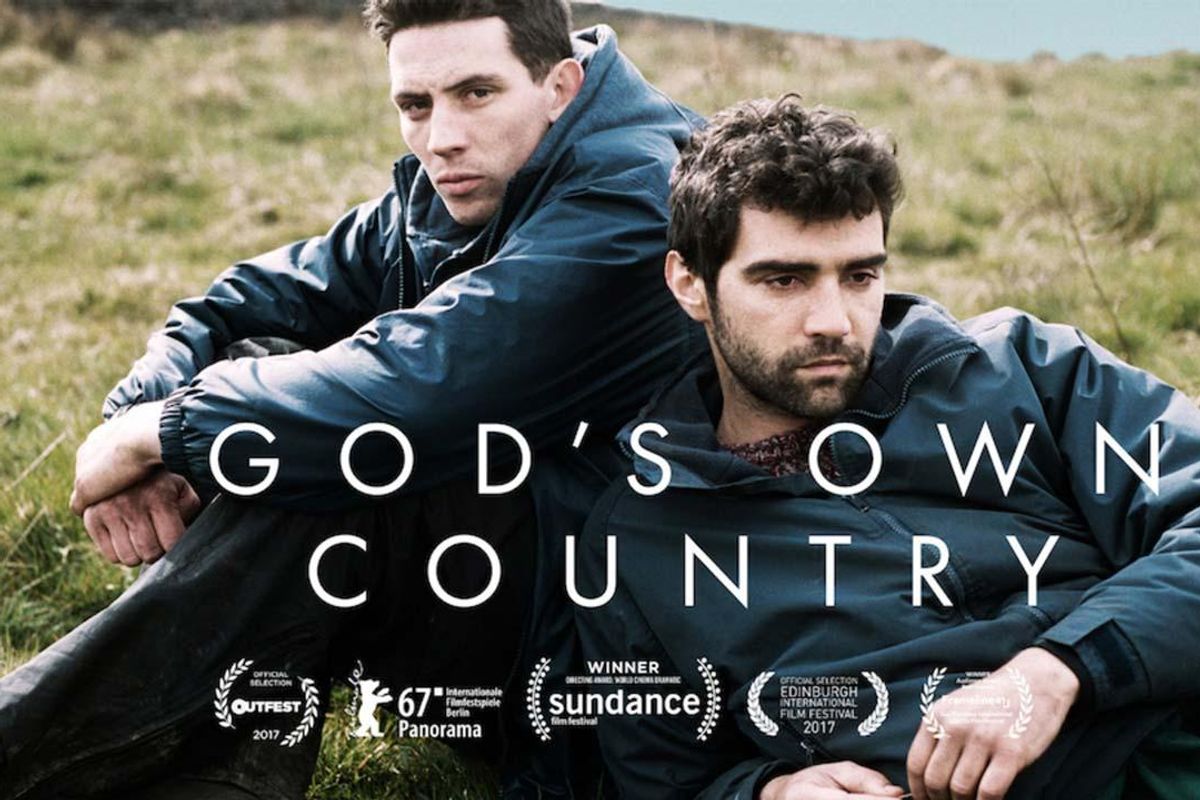 two actors in the movie God's Own Country leaning on each other in a green meadow.