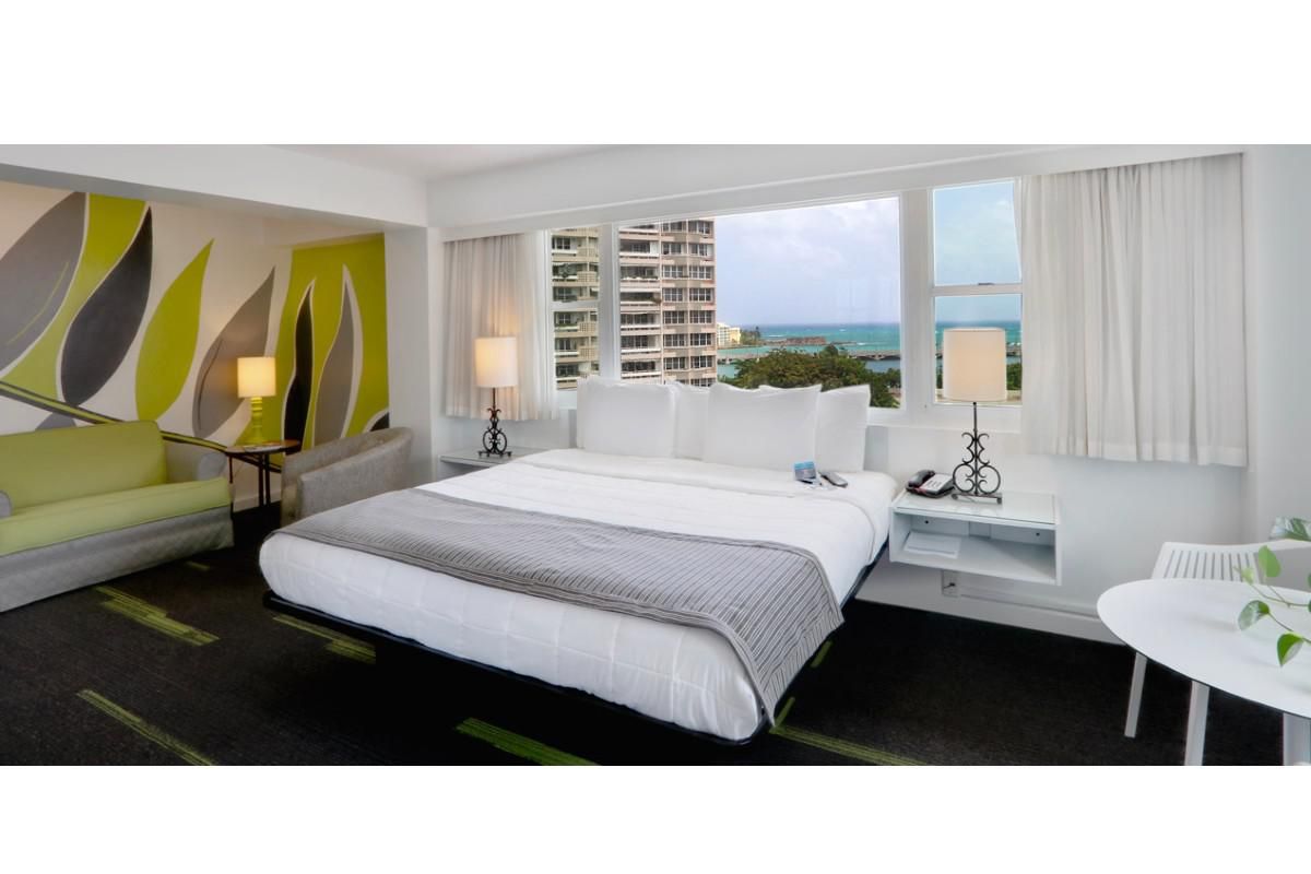 king size bed positioned in front of the window overlooking the ocean.