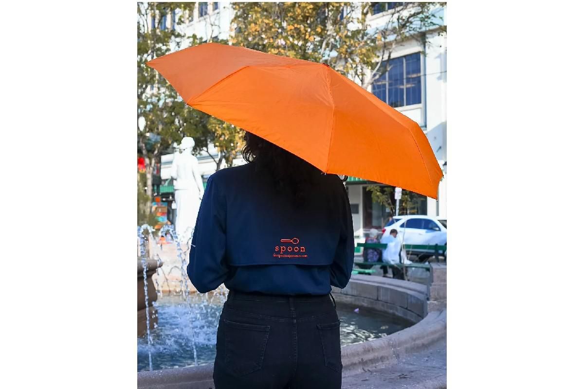tour guide from the spoon experience holding an orange umbrella.