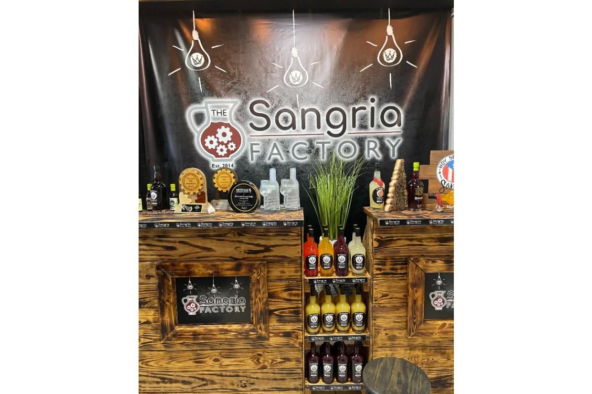 a counter with different flavored bottles of sangria from the sangria factory.