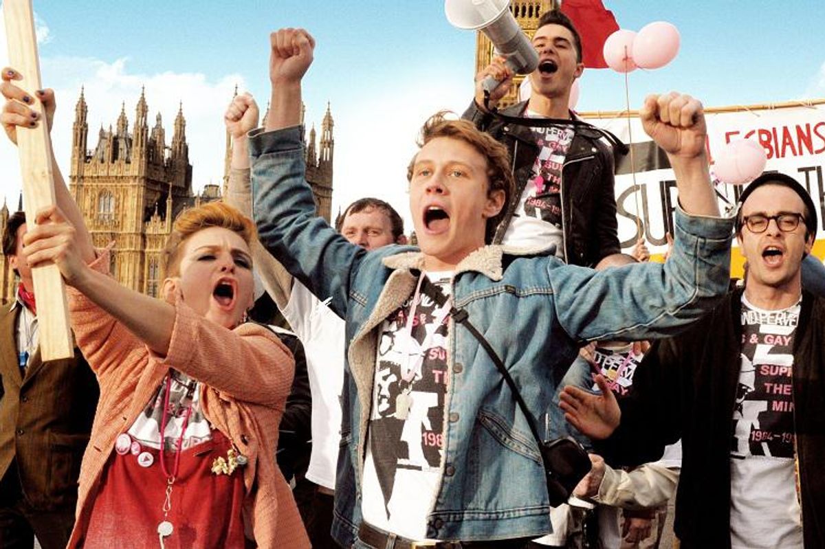 People shouting with their fists in the air during a gay protest.
