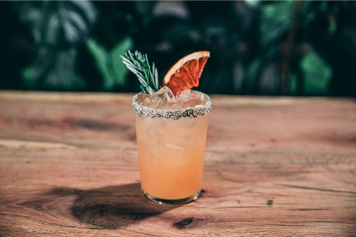 salty dog tequila cocktail with rosemary sprig and grapefruit wedge.