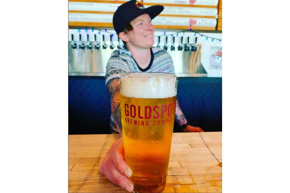 Kelissa Heiber at Goldspot Brewing Co. holding a beer.
