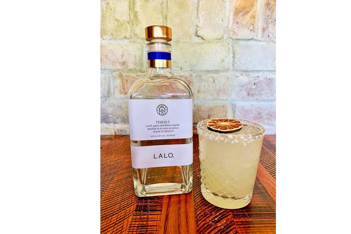 Lalo tequila bottle next to a margarita.