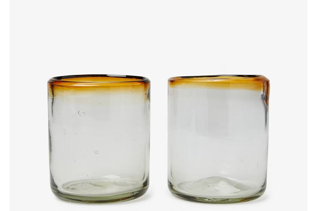 two handblown glass tumblers with brown colored glass along the rim sitting next to each other.
