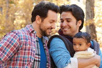 gay couple holding a baby.