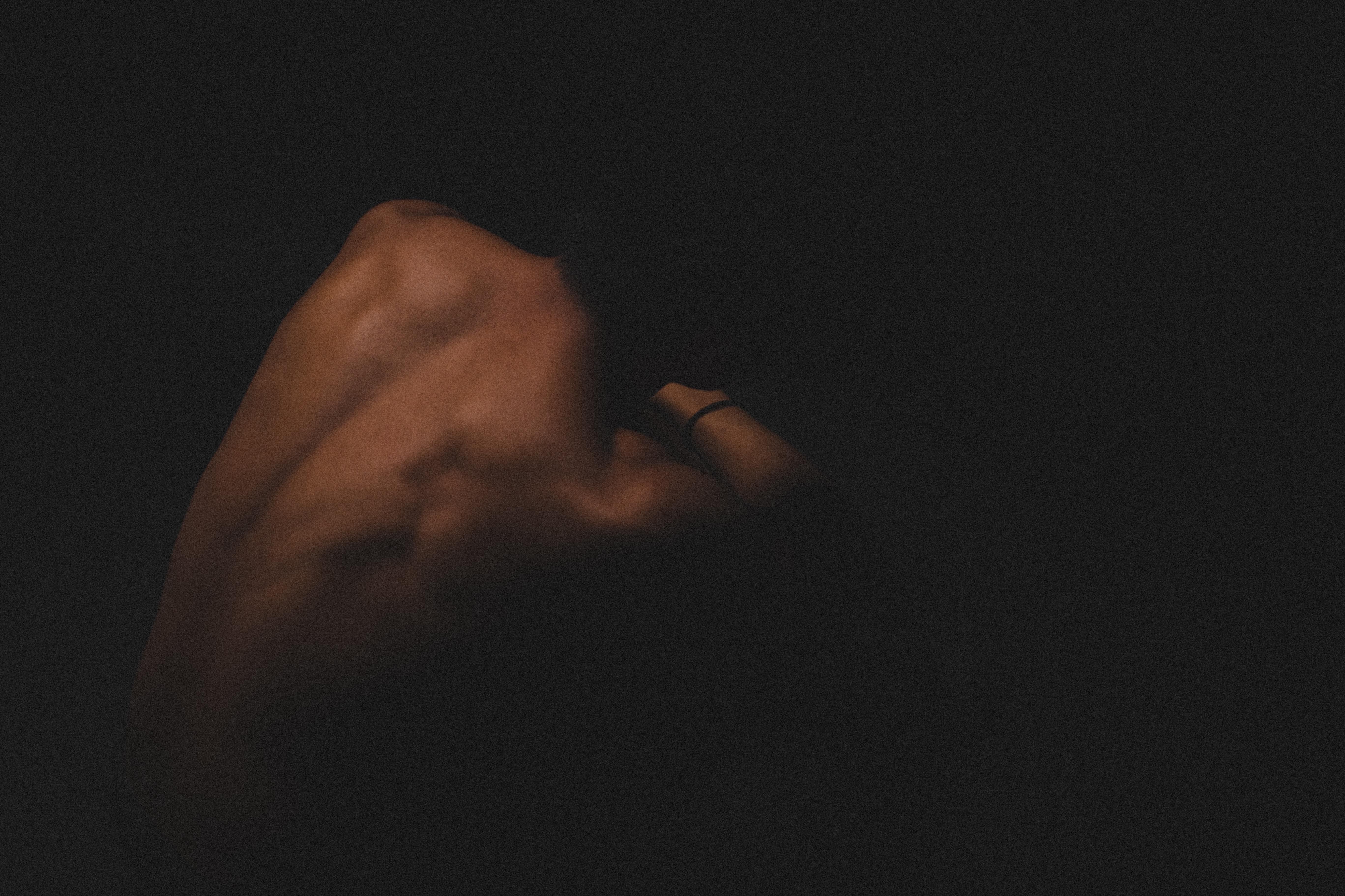 A naked person cowering in the dark