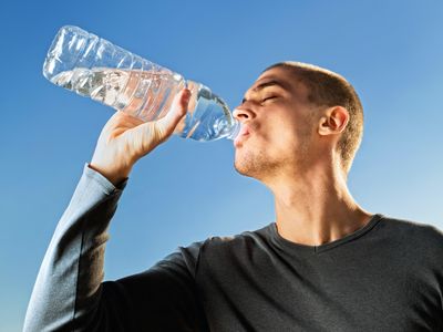 man in black crew neck shirt drinking water