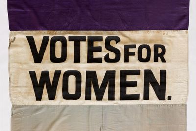 purple and white banner advocating voting rights for women