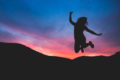 silhouette of person jumping during dawn