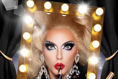 Drag queen looking in a mirror surrounded by lights