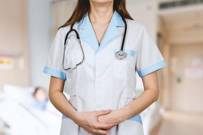 woman in white button up shirt and blue stethoscope.