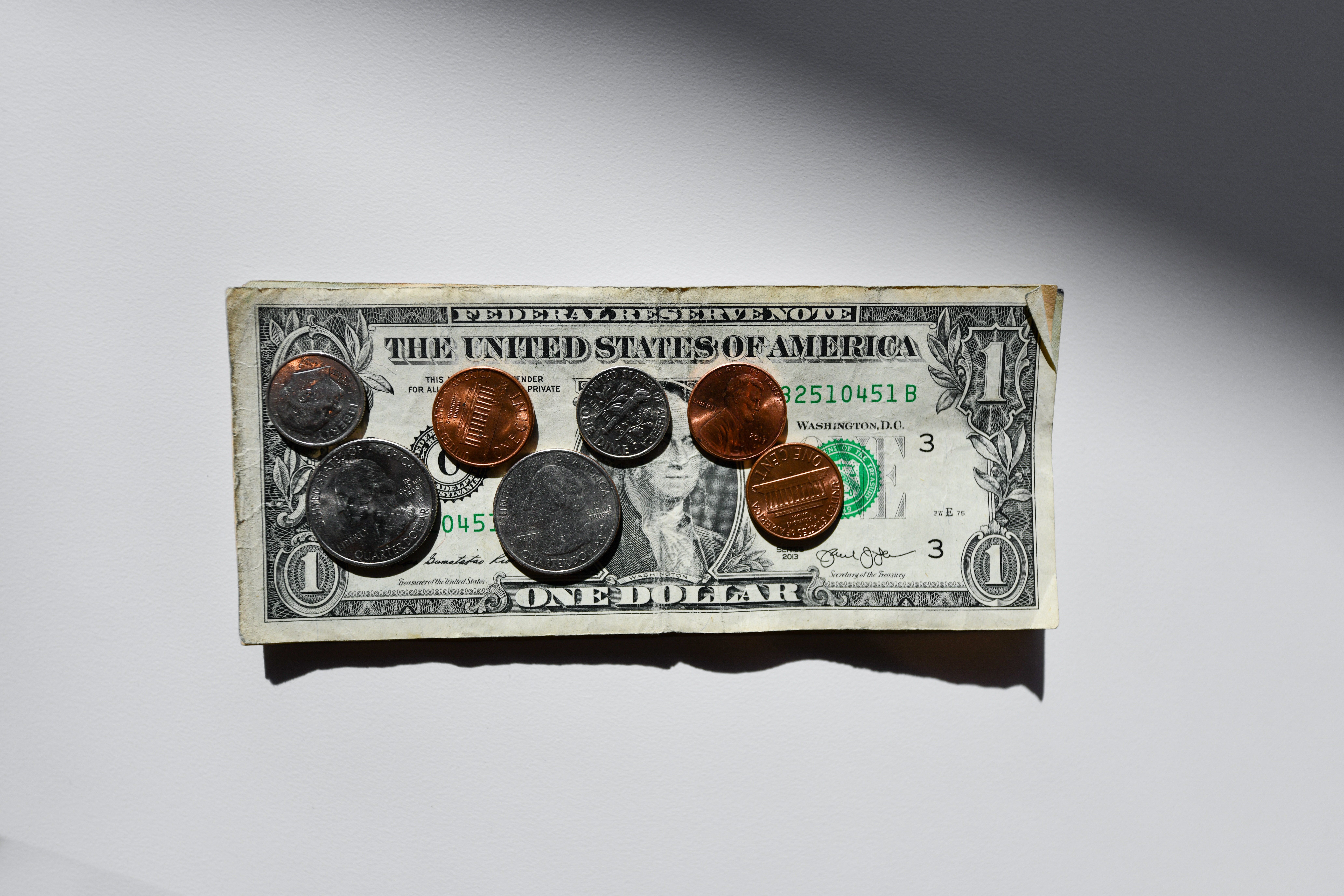 coins sitting on top of a U.S. dollar bill.