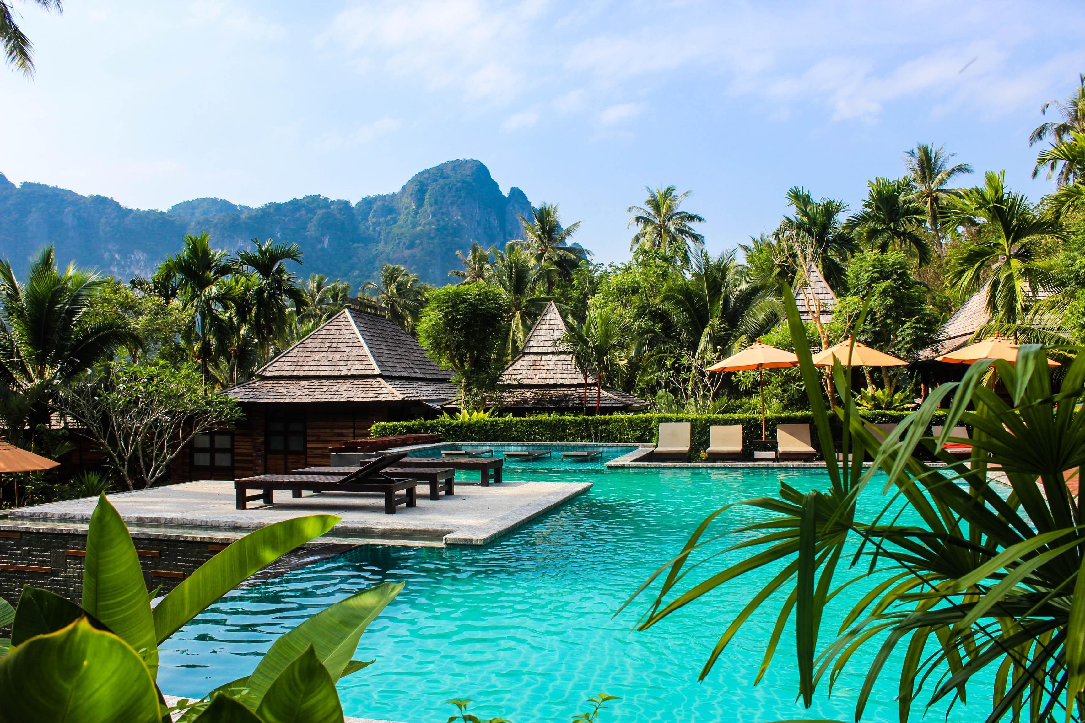 view of mountains, huts, and a swimming pool in Thailand.