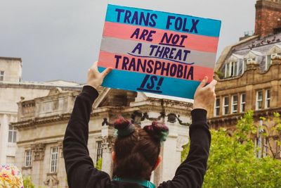 Woman holding up pro-trans sign