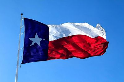 blue white and red Texas flag waving in the wind.